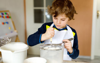 Pictures is a boy cooking in his home.