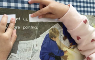 A St Gertrudes Catholic Primary School Smithfield kindy student uses two strips of paper to isolate two words within a full sentence