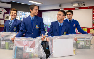 Catholic Intensive English Centre students Yoneel Marzeena, Danial Mati, Yohan Al-Lalo and Noel Jamil receiving donated education packs.