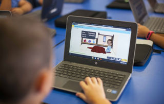 A primary school student learning online on his laptop