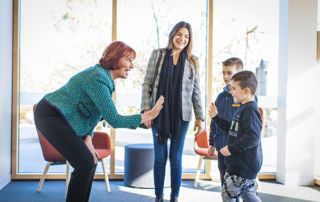 All Hallows Catholic Primary School Five Dock principal Helen Elliott gives a high-five to a boy pupil