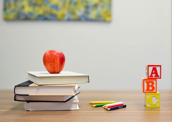 Books, pencils, number blocks and an apple