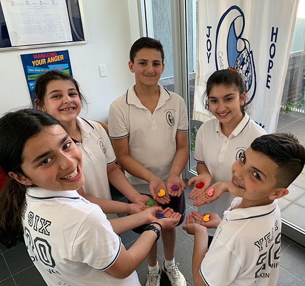 Marion Catholic Primary School students hold felt hearts they have made to donate