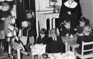 Sister Aidan Hayes teaches St James' kindy students in 1956