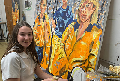 Bronte Stark from De La Salle Cronulla in front of her painting of firefighters