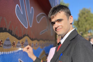 A Marist College Eastwood male students helps create an Indigenous mural with Wandana artists