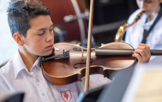 Trinity College Auburn Regents Park male student plays violin as part of Amadeus Music Education Program