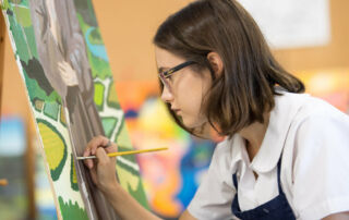 A secondary student is painting